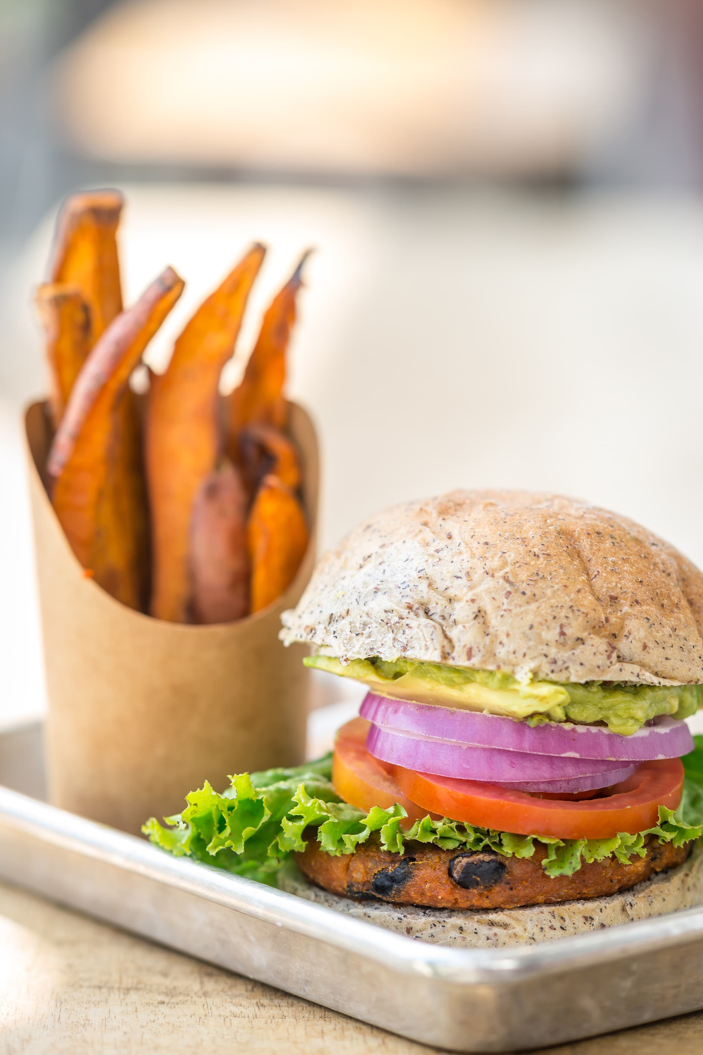 Plant burger with lettuce, tomato, and sweet potato fries